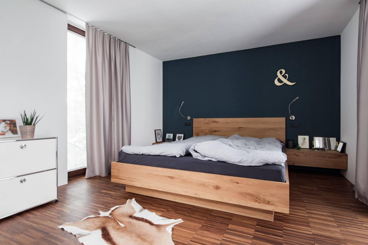 Maßgefertigtes Schlafzimmer aus natürlichem Eichenholz und dunkelblauer Wandgestaltung in modernem Design © Heike Schwarzfischer Interiordesign in Landshut bei München